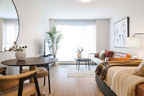 A modern bedroom with a large bed and a round table with chairs.