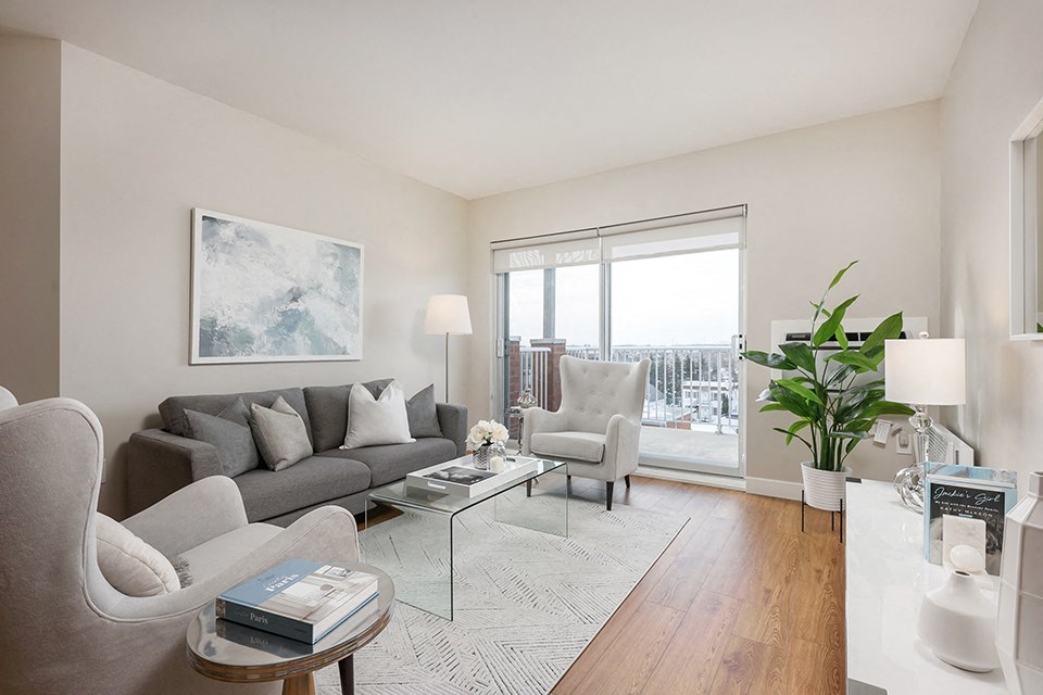Bourg Du Village living room with sliding patio door leading to balcony in Sainte Therese, QC