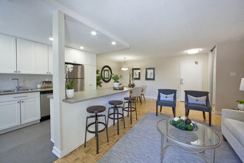 a living room with a kitchen and a table with chairs