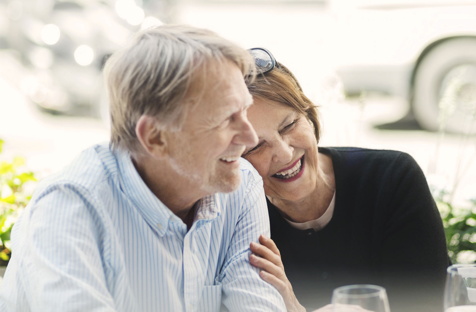 Mature adults laughing on terrace, enjoying Realstar’s apartment garden
