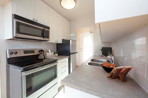 A kitchen with a stove, microwave, and refrigerator.