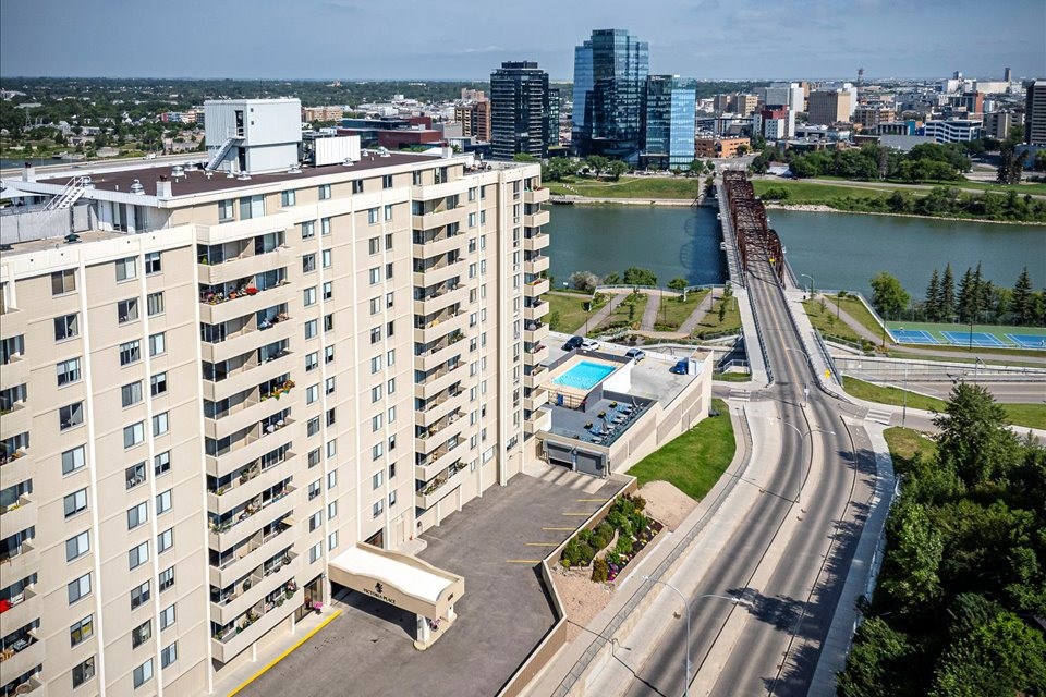 A tall apartment building with a truck parked in front of it.