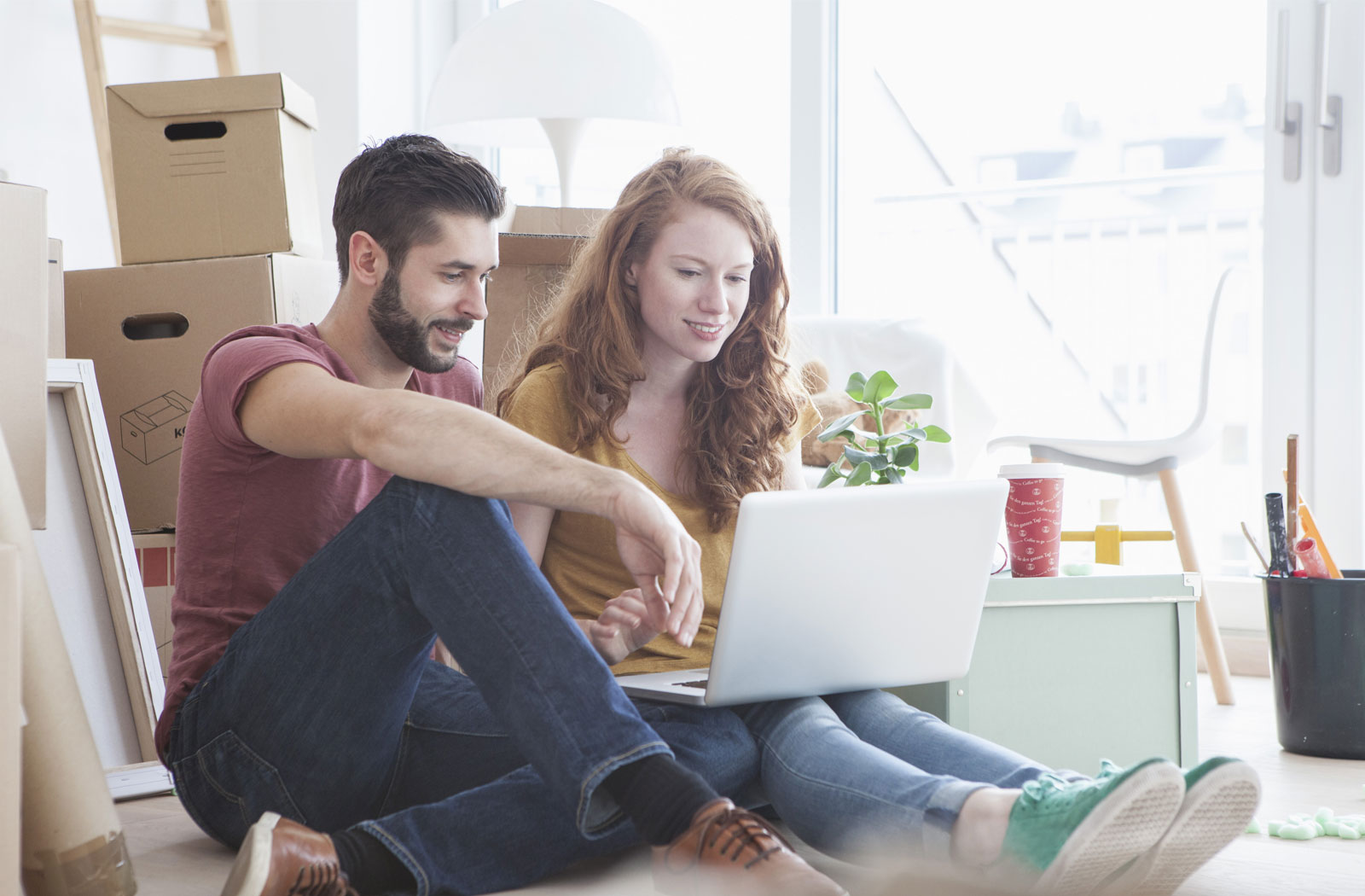 Young couple renting, on laptop, moving into Realstar apartment