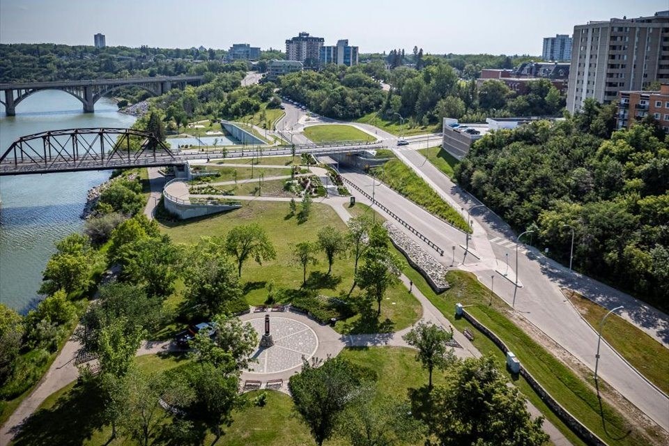 an aerial view of a park with a river and a bridge