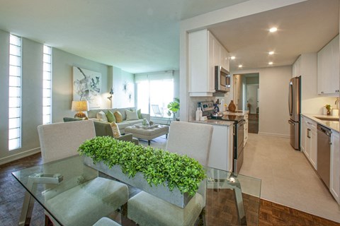 a living room and kitchen with a glass table