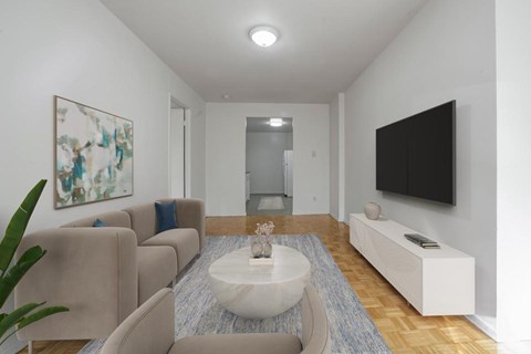 A living room with a white couch and a painting on the wall.