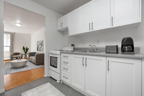 A kitchen with white cabinets and a black toaster.
