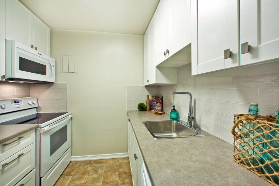 Wellington Park Towers kitchen with full range stove and microwave in St. Thomas, ON
