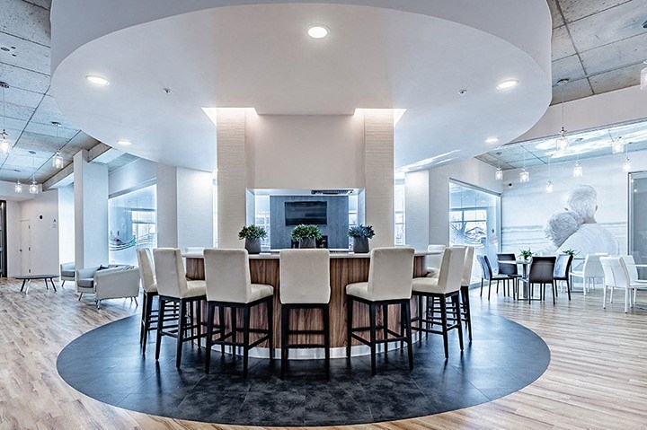 Private kitchen with circular bar in modern social room at La Voile Broisbriand apartments in Broisbriand, Quebec