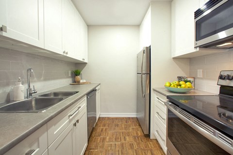 A kitchen with white cabinets and stainless steel appliances.