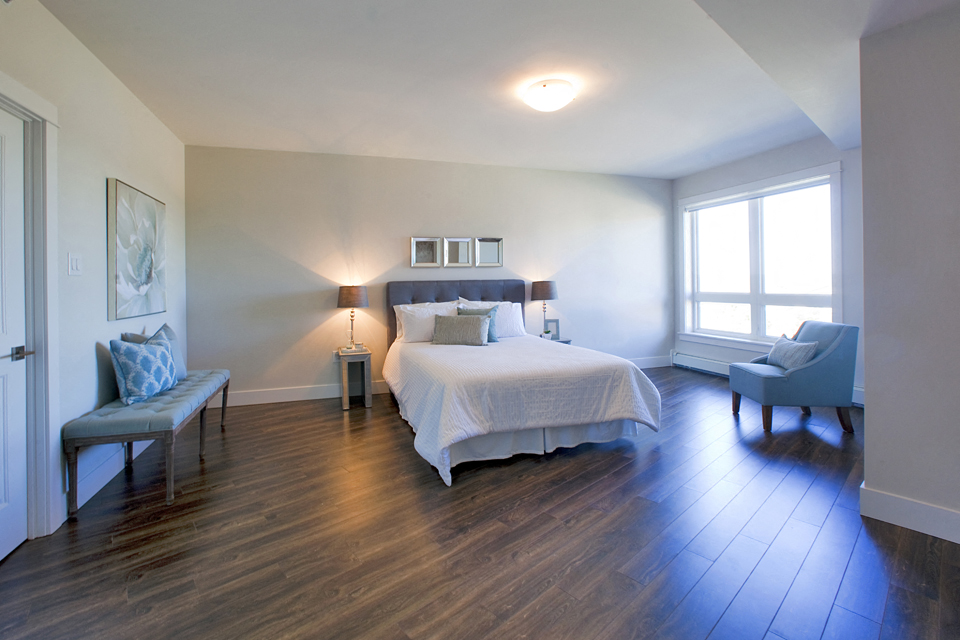 Amesbury Gate Bedroom with a blue chair next to the window in Bedford, NS