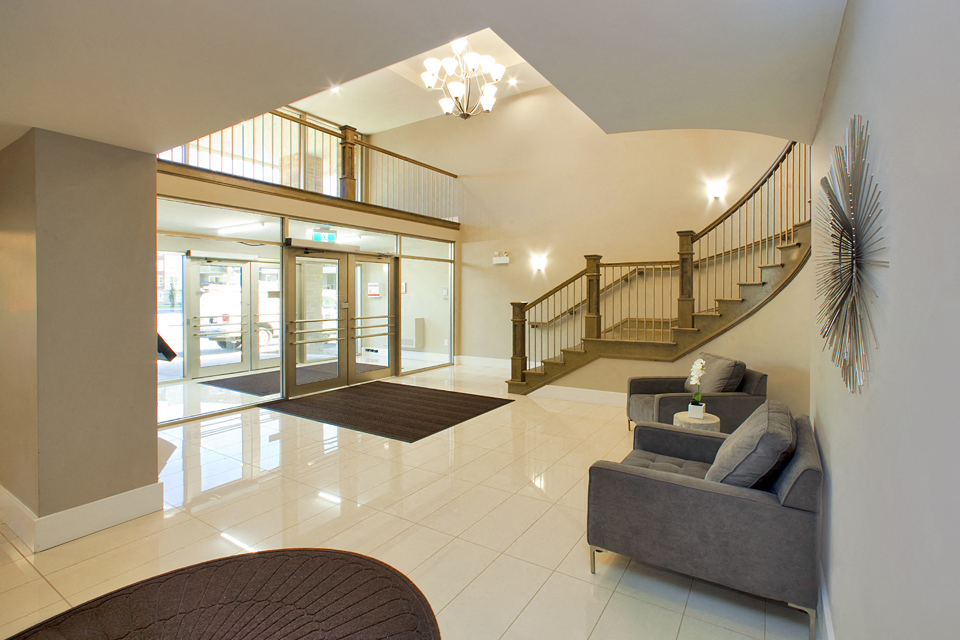 Amesbury Gate Fancy lobby with bright chandelier and staircase in Bedford, NS