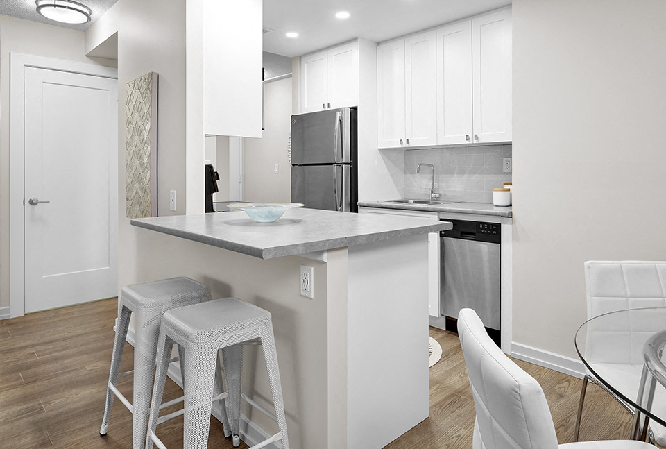 Avalon Apartments kitchen featuring stainless steel appliances and breakfast bar in Edmonton, AB
