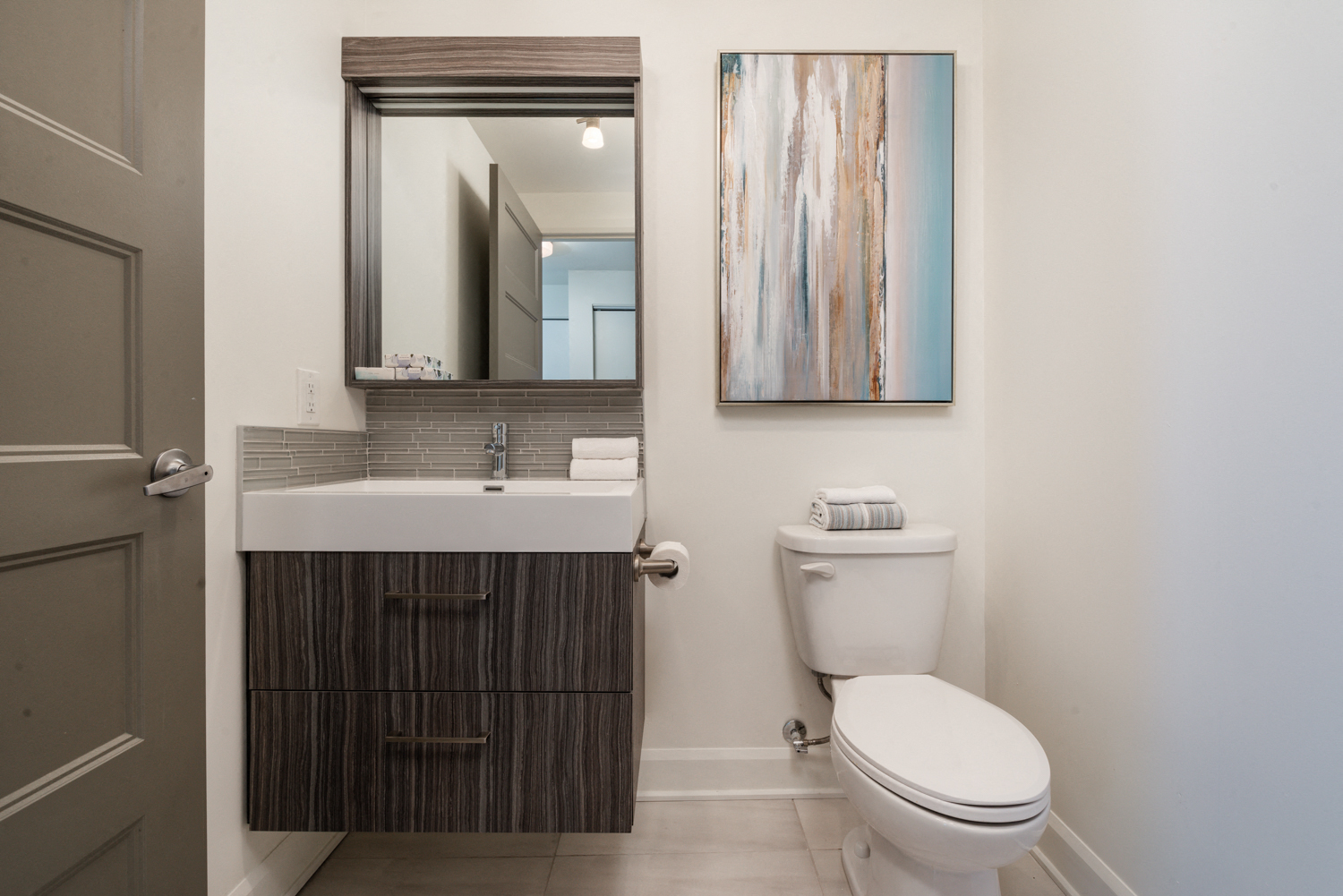 Modern half bath with spa premier finishes at Axial Towers apartment in Laval, Quebec