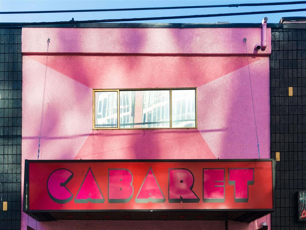 Pink building with sign that reads cab