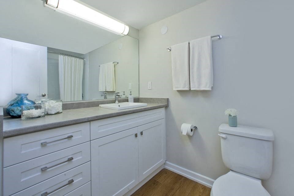 a bathroom with a toilet sink and mirror