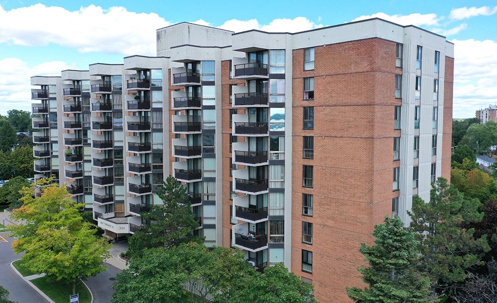 a large apartment building with balconies and trees in front of it
