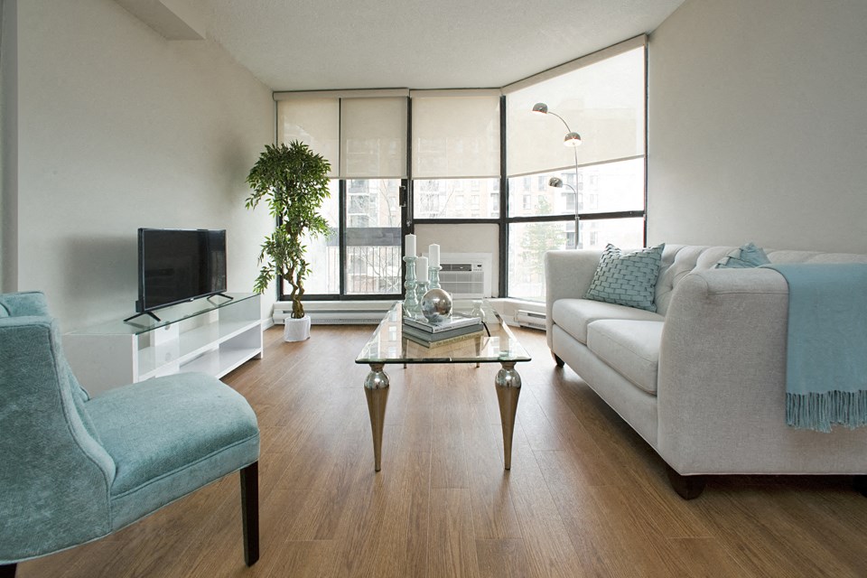Bay Terrace elegant living room with large floor to ceiling window and balcony access in Belleville, ON