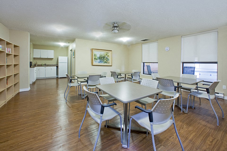 Bay Terrace social room with tables and chairs and kitchenette in Belleville, ON