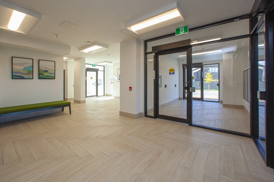 Lobby with wood-look tile flooring, looking towards entrances at Bayfield Tower Apartments in Barrie, ON