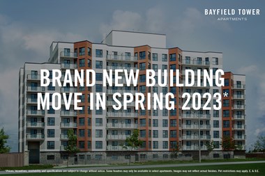 Bayfield Tower Apartments in Barrie, ON exterior image with text overlay saying "Brand New Building Move In Spring 2023*"