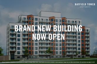 Bayfield Tower Apartments in Barrie, ON exterior image with text overlay saying "Brand New Building Now Open"