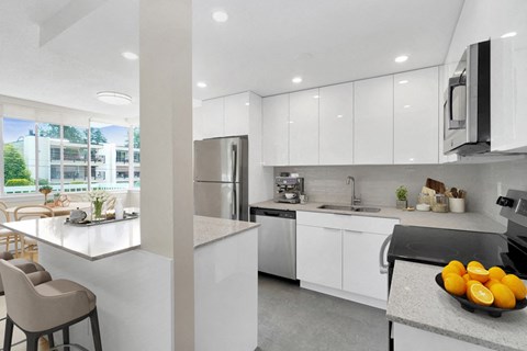 a kitchen with white cabinets and a bowl of fruit