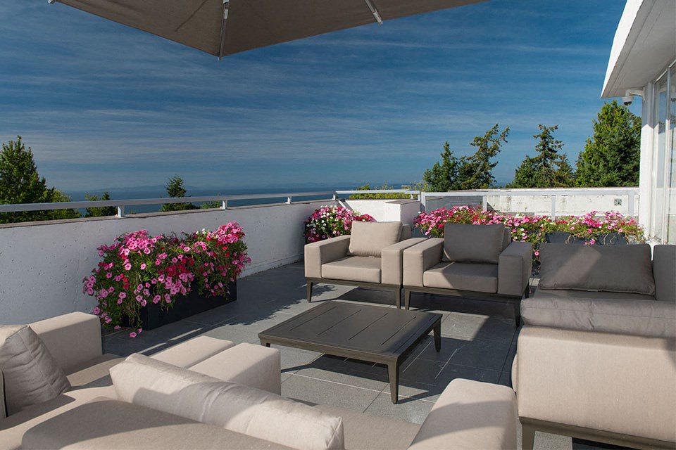 Bayview Gardens Apartments outdoor patio featuring lounge seating and flower planters in White Rock, BC