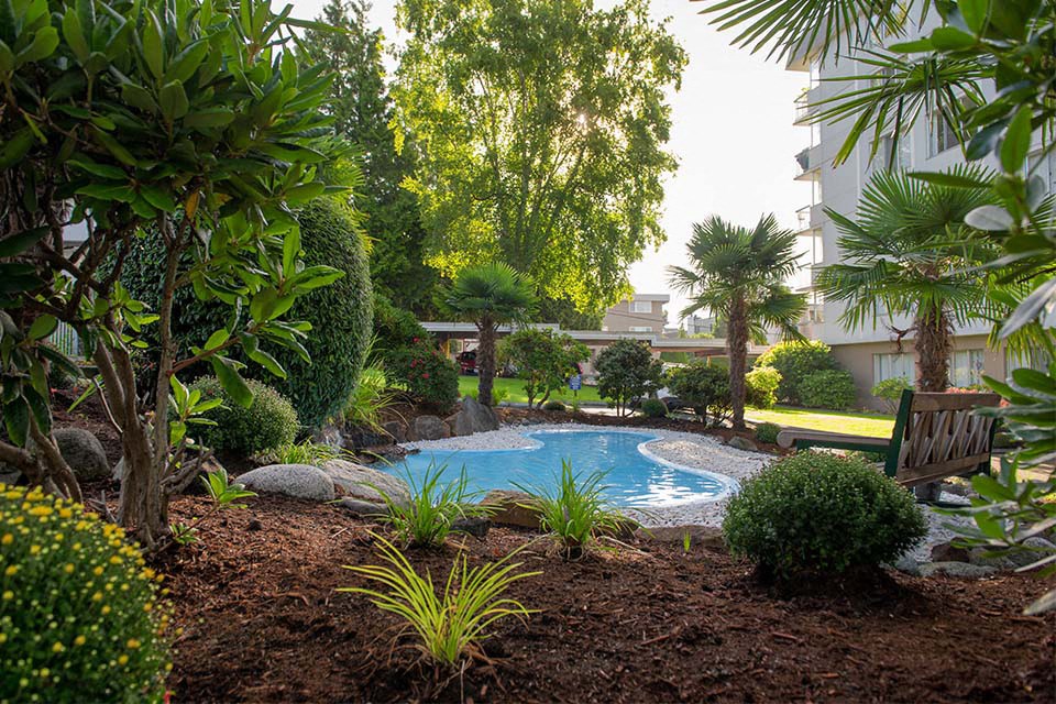 Bayview Gardens Apartments outdoor pool featuring bench seating and landscaping in White Rock, BC