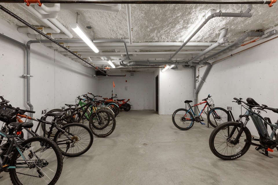 A bike parking area with bikes on both sides of the room at The Ambrosi in Kelowna, BC.