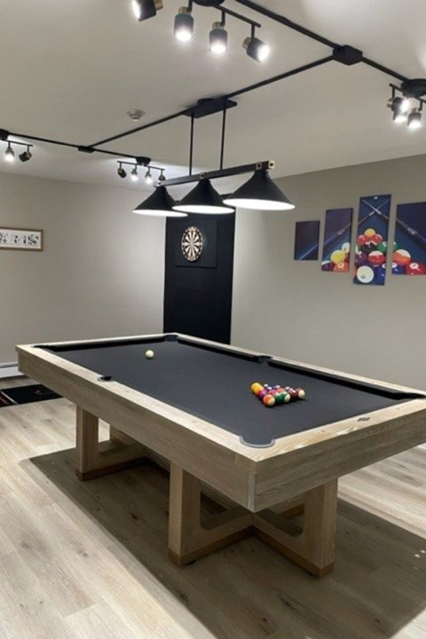 A pool table with a cue ball and a rack of balls ready to be played.