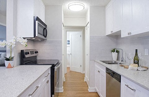 Braemar Gardens apartments kitchen featuring stainless steel appliances view into hallway in Coquitlam, BC