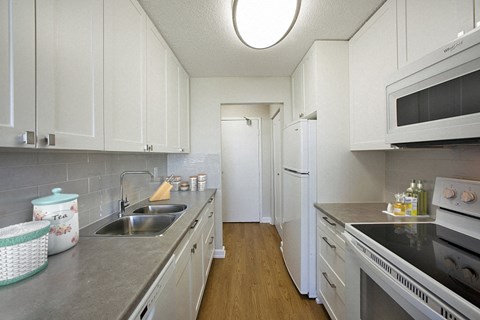 a kitchen with stainless steel counter tops and white cabinets