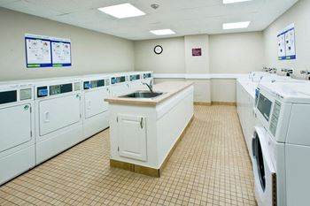 Laundry room with ample washers and dryers at Britannia by the Bay Apartments in Ottawa, ON