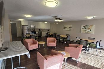 Social room at Brockville Apartments with full kitchen, lounge and dining seating
