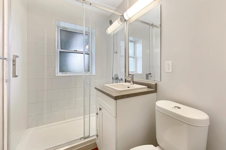 A white toilet sits next to a sink in a bathroom.