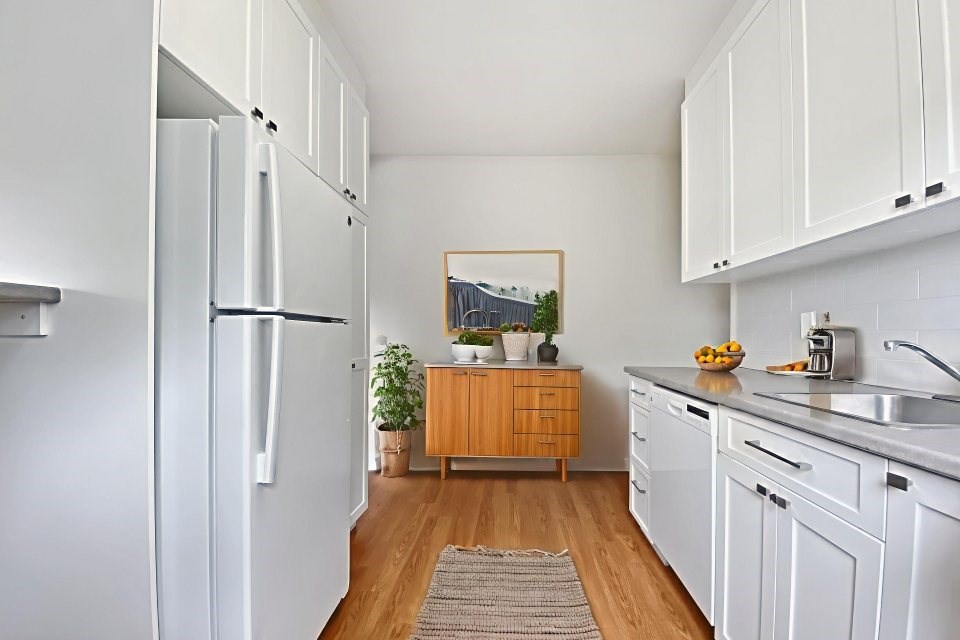A kitchen with white cabinets and a wooden counter.