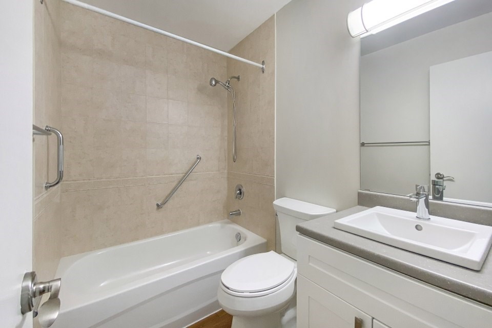 A white toilet sits next to a bathtub in a bathroom.
