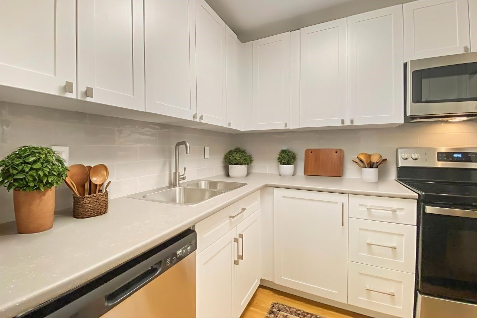 A kitchen with white cabinets and a black oven.