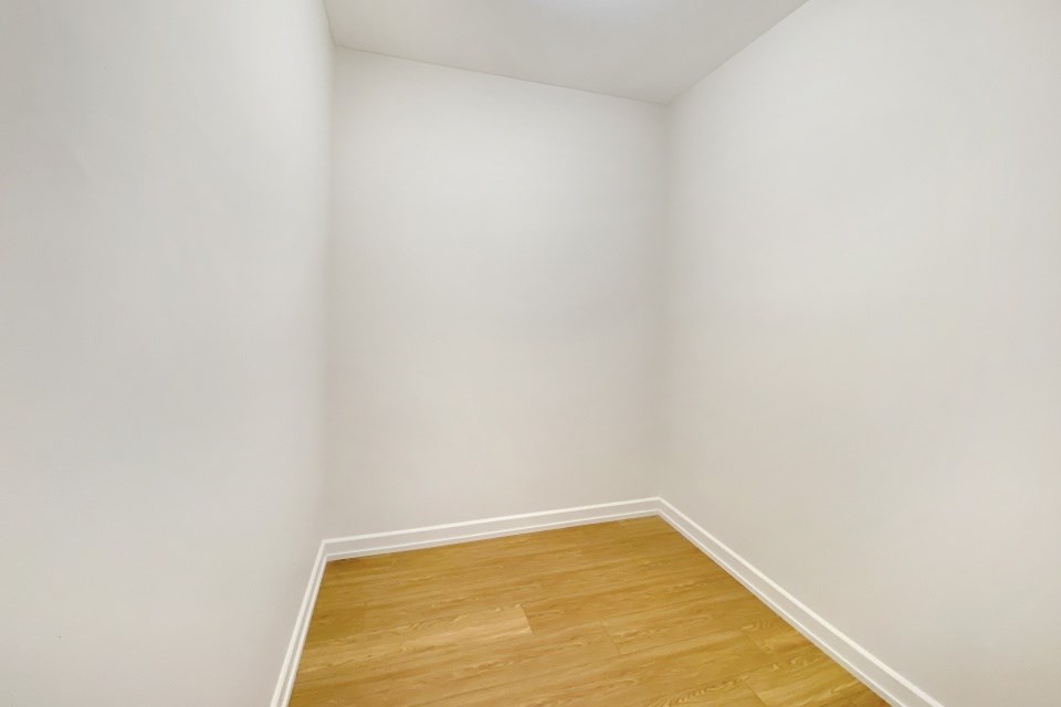 A corner of a room with wooden flooring.