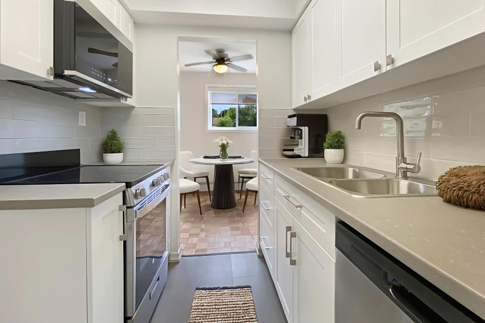 A kitchen with white cabinets and a black countertop.