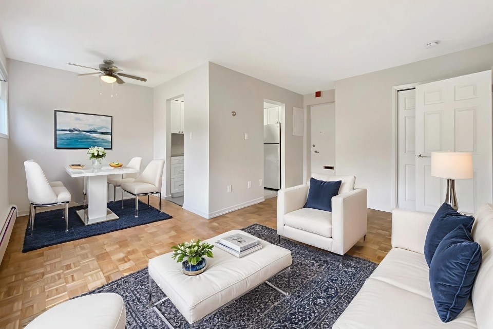 A living room with a white couch, a white coffee table, and a painting on the wall.