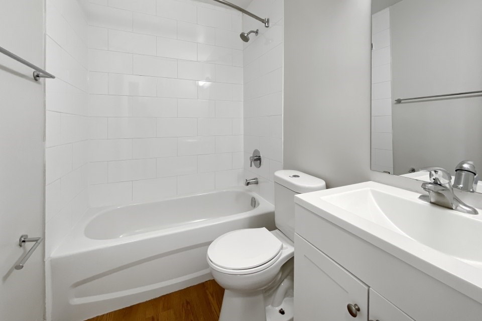 A white bathroom with a toilet, sink, and bathtub.