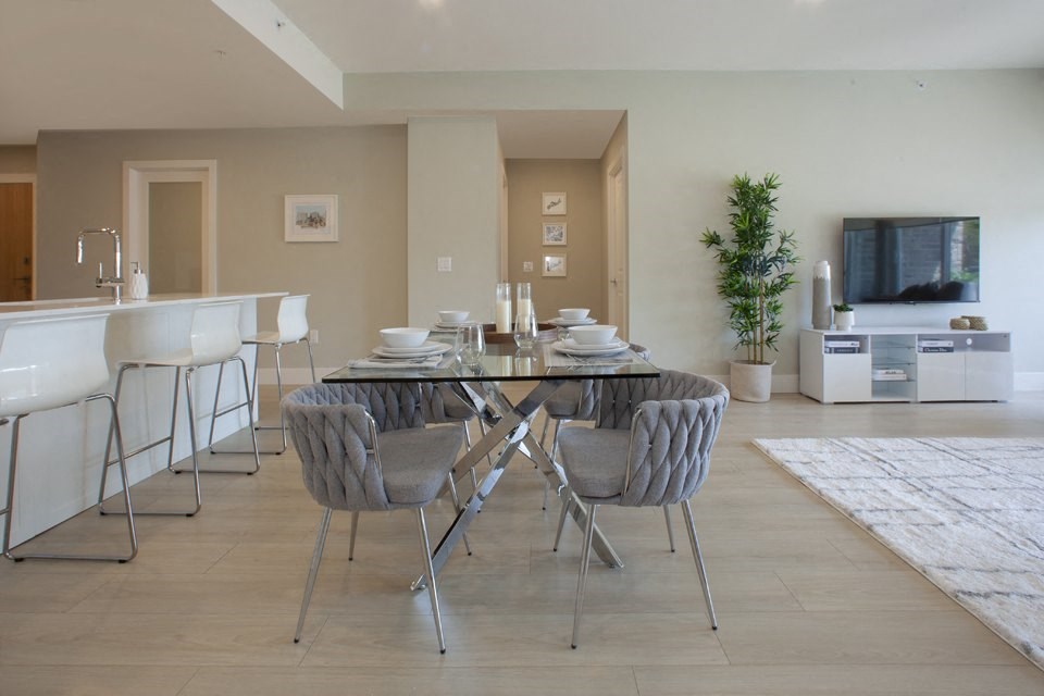 a dining room with a glass table and chairs