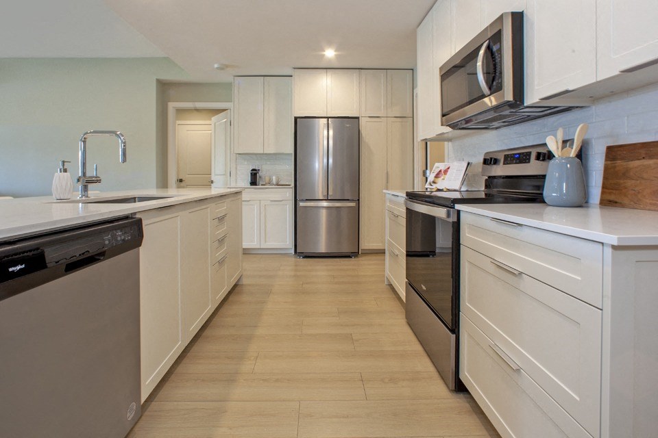 a kitchen with white cabinets and stainless steel appliances