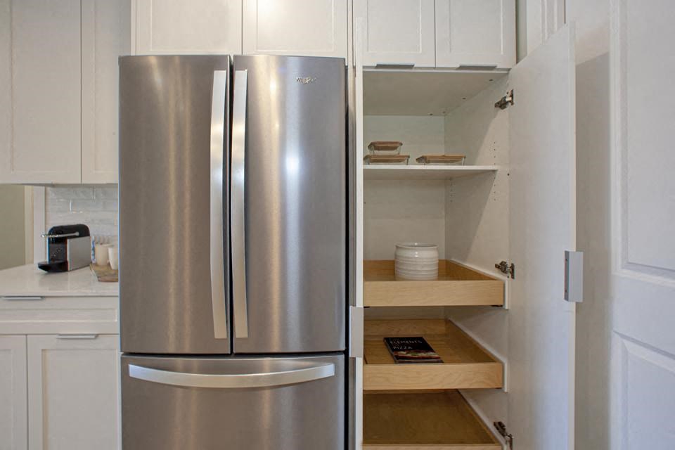 a kitchen with a refrigerator and some shelves