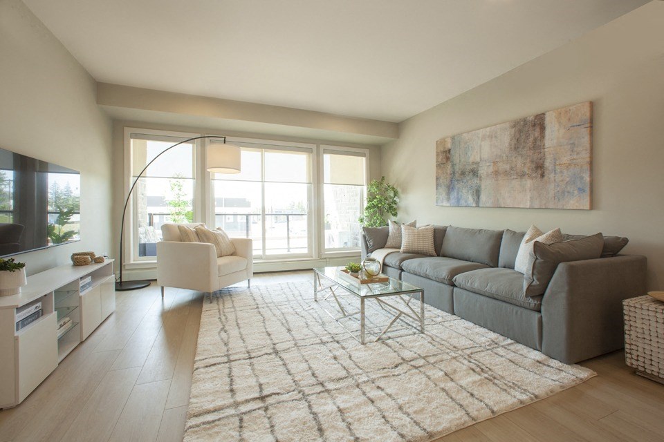a living room with a gray couch and a white chair