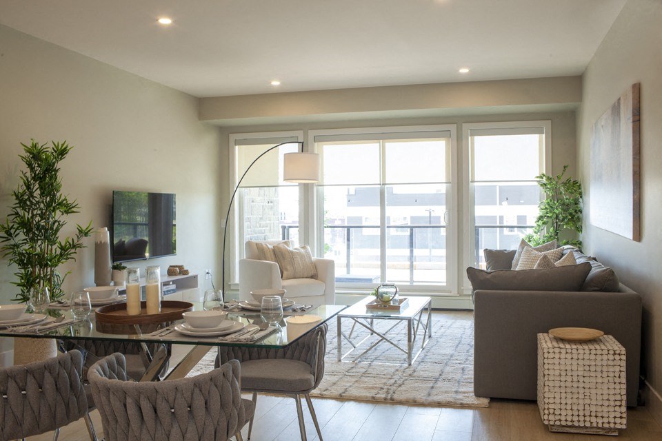 a living and dining area with a glass table and chairs and a large window