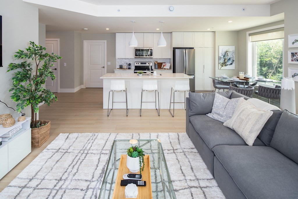 a living room and kitchen with a couch and a table