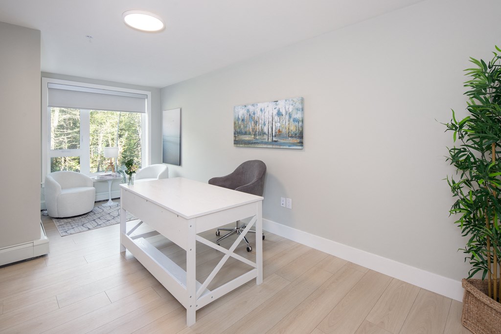 a home office with a white desk and chair and a large window